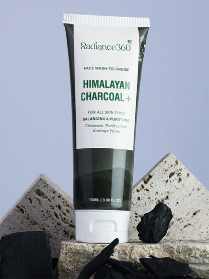 Radiance360 Himalayan Charcoal face wash tube on a stone surface with charcoal pieces.